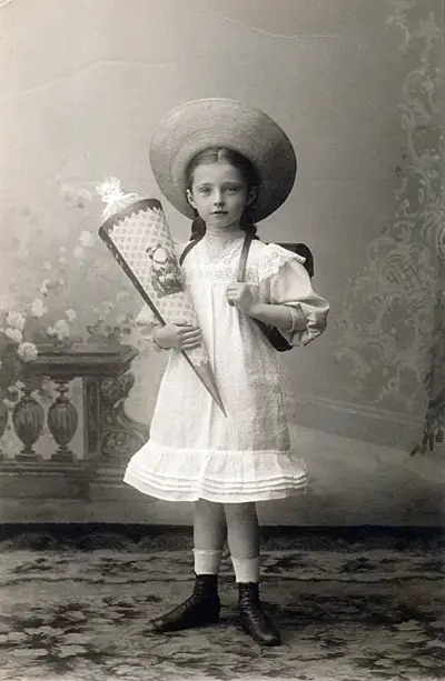 Schülerin mit Strohhut und Schultüte, um 1900